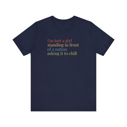 Navy blue t-shirt with colorful text "i'm just a girl, standing in front of a nation, asking it to chill"