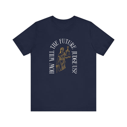 Navy blue t-shirt with sketch of lady justice and words in white arched around it "how will the future judge us?" 