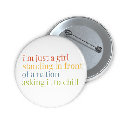Button badge with colorful text 'i'm just a girl standing in front of a nation asking it to chill' on a white background