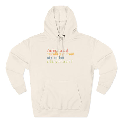 Beige hoodie with colorful text "i'm just a girl standing in front of a nation asking it to chill"