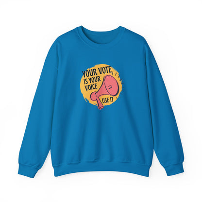 Blue sweatshirt with a coral megaphone graphic against a bright yellow circle and black text "your vote is your voice, use it"