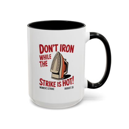 White ceramic 15 oz coffee or tea mug with black interior and handle with "don't iron while the strike is hot" red text and a vintage iron graphic
