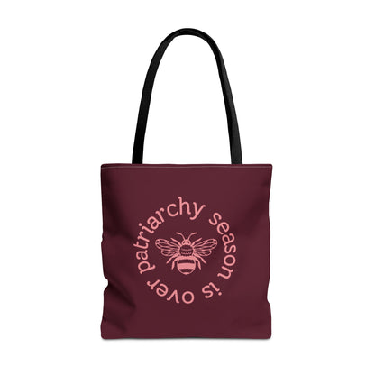 Maroon tote bag with black handles with pink "patriarchy season is over" text circling around a queen bee graphic 