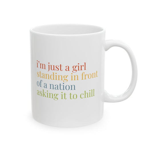 White ceramic 11 oz coffee or tea mug with colorful "I'm just a girl, standing in front of nation, asking it to chill" text