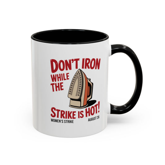 White ceramic 11 oz coffee or tea mug with black interior and handle with "don't iron while the strike is hot" red text and a vintage iron graphic