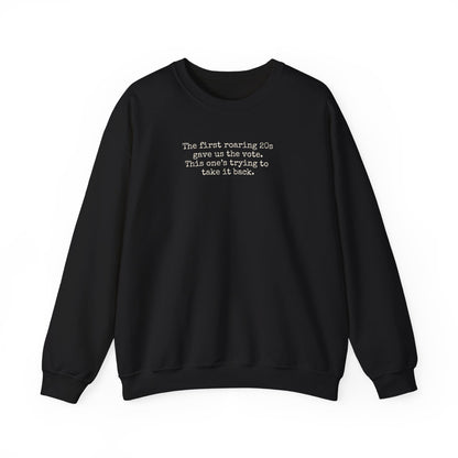 Black unisex crewneck sweatshirt with "the first roaring 20s gave us the vote. This one's trying to take it back" cream text