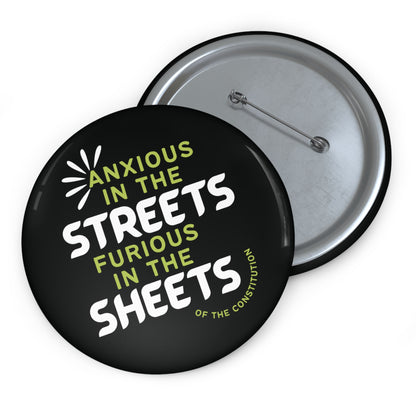 Black pin button with "anxious in the streets, furious in the sheets (of the constitution)" lime green and white text