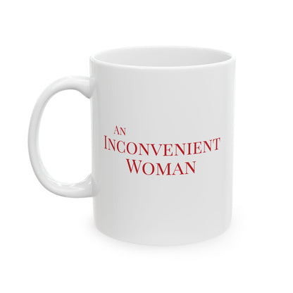 White 11 oz mug with red text 'AN INCONVENIENT WOMAN' 
