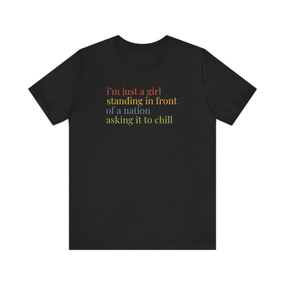 Black t-shirt with colorful text "i'm just a girl, standing in front of a nation, asking it to chill"